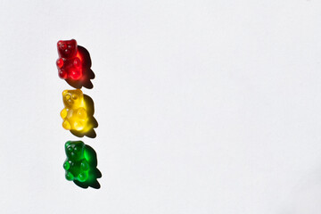 Top view of colorful gummy bears on white background with copy space.