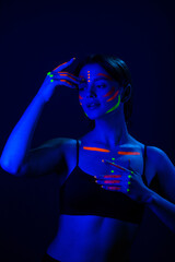 Unusual fluorescent makeup on the skin of a beautiful woman, glowing under ultraviolet light.