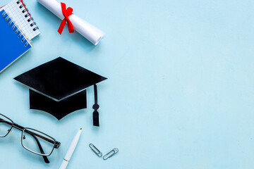 Graduation hat or academic cap on desk with students supplies