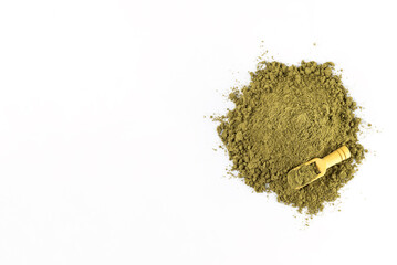 A heap of hemp protein with a wooden spoon on a white background. Horizontal orientation, top view, copy space.