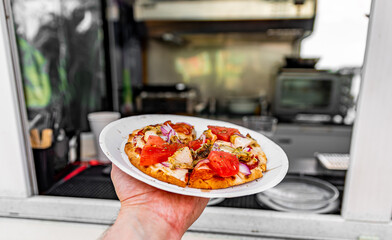 man holds plate with mini pita pizza in hands. Street food, fast food outdoor
