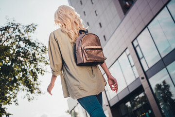 Rear back behind view portrait of attractive blond girl strolling going to university study abroad...