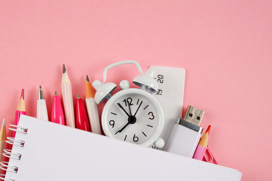Notepad, pens,pencils,ruler,flash drive, paper clips in pink and white tones.Goods for businessmen, schoolchildren,students, teachers.Planning,sale of office supplies for the academic year.Copyspace