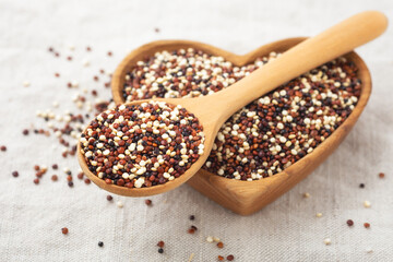 Quinoa in spoon on heart wood bowl