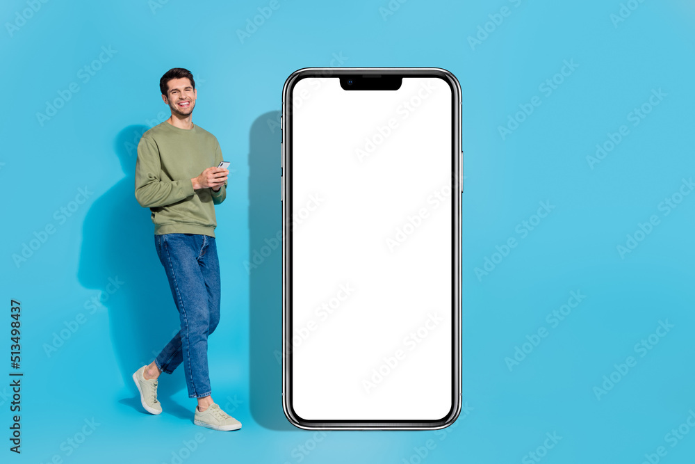 Poster Full length photo of cheerful person hold telephone empty space web blank isolated on blue color background