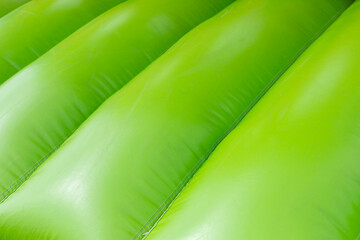 Green inflatable trampoline. Obstacle course. Details of amusement park. - obrazy, fototapety, plakaty