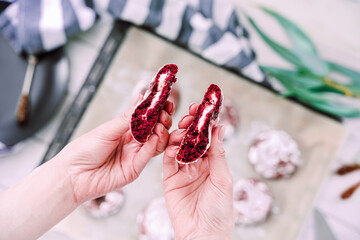 Crispy cookies. Red velvet cookies with cream filling on a baking sheet. Female hands broke the...