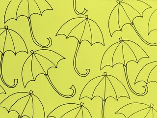 Pattern of umbrellas drawn black marker on color paper background. Seamless background with umbrellas. Autumn background.