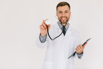 Male doctor with a folder in defocus holding a stethoscope on a white background