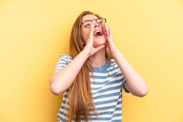 Young caucasian woman isolated on yellow background shouting excited to front.