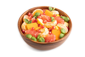 Vegetarian fruit salad of pumpkin, tangerine, pomegranate, microgreen sprouts isolated on white, side view, close up.