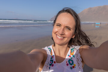 Happy female tourist taking selfie near sea