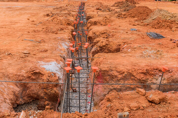 A construction site is being prepared with steel for its foundation by a trench on construction site