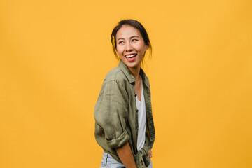 Portrait of young Asia lady with positive expression, smile broadly, dressed in casual clothing over yellow background. Happy adorable glad woman rejoices success. Facial expression concept.