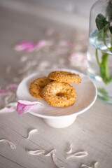 Cookies on white background. Homemade concept. Flat lay, top view. Mock up with cookies on a straw basket, teapot, tea sachet, dried flowers, cinnamon powder, late, sisal rope and linen fabric.