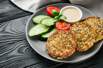 quinoa cutlet with vegetables on a black wooden rustic background