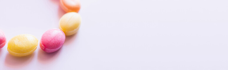 Close up view of colorful lollipops on white background with copy space, banner.