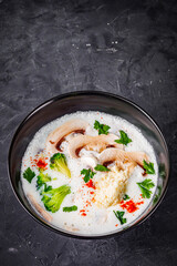 creamy mushroom soup with champignons on a black background