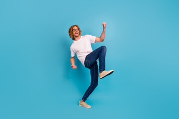 Full body portrait of delighted astonished person raise fists achievement isolated on blue color...