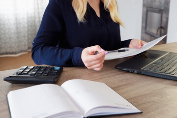 pretty accountant working with computer and calculator. Businesswoman or accountant works on a desk within an office using a calculator to calculate the budget. Financial and investment concept.