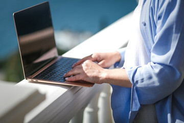 Close-up of a laptop with female hands outdoor