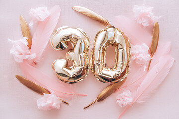 Happy thirtieth birthday with golden number thirty 30 air balloons and feathers with colorful decorations on pink