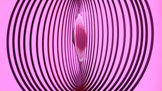 abstract rotation of a round pink figure on a pink background. slow motion