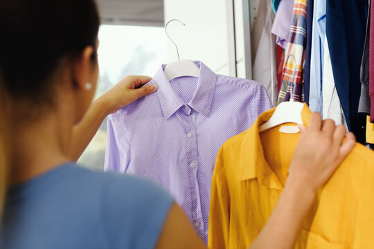 Woman comparing clothes in her wardrobe