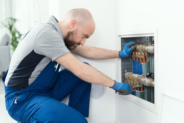 Professional plumber installing plumbing manifolds - obrazy, fototapety, plakaty
