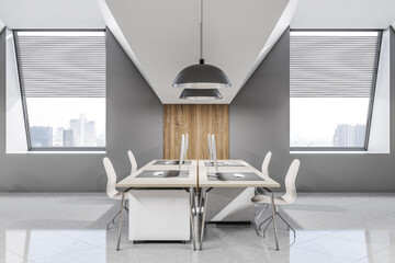 Side view on stylish light work places in spacious sunlit office with glossy floor, wooden tables, grey walls with wooden decoration and city view from windows with blinds. 3D rendering