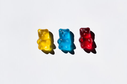 Top view of colorful gummy bears on white background.