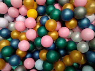 Colorful plastic balls for kids playground of metallic colors and pink