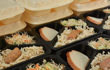 Lunch boxes (salad, chicken leg, pasta). Free lunches for needy and internally displaced persons. Lunch delivery concept. Online orders
