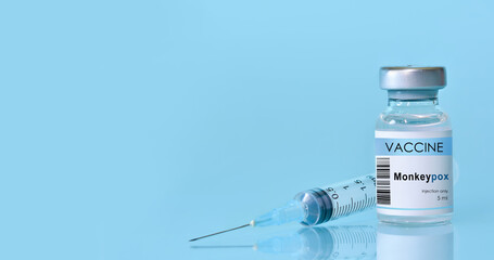 Vaccine Monkeypox and Smallpox vial with a syringe on a blue background.The concept of medicine, healthcare and science.Copy space for text.