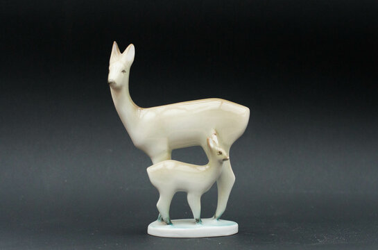 Mid-century modern porcelain figurine - deer mom and fawn isolated on black background