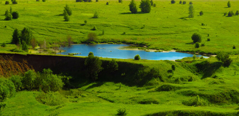 Summer day. blue lake on green plains and hills