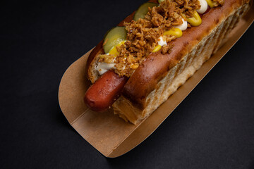 Hot dogs in paper plates with sausages and sauce 
