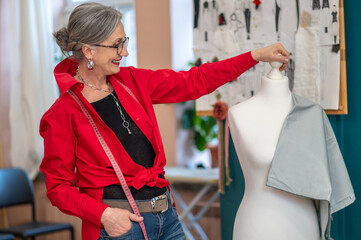 Profile of happy woman with measure touching mannequin