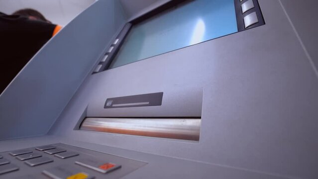 Woman's hand takes banknotes out of ATM in bank or room. Public place. . concept of finance, money, bank and people - close-up of hand withdrawing cash from ATM. Cashing out currency or money.