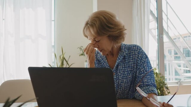 Beautiful senior woman using laptop computer at home. Businesswoman working from home. Concept about lifestyle, business and technology
