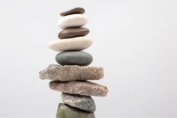 pyramid of stacked stones on a light background. stabilization and balance in life