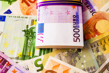 A pack of European currency lies on the background of the Euro
