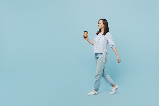 Full Body Young Happy Smiling Woman She 20s Wear Casual Blouse Hold Takeaway Delivery Craft Paper Brown Cup Coffee To Go Isolated On Pastel Plain Light Blue Background Studio People Lifestyle Concept