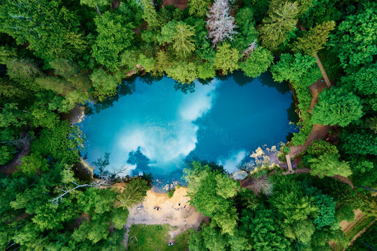 Blue lake in the middle of green forest, aerial view. Wild colorful lake in mountain park in Poland. Beautiful nature landscape