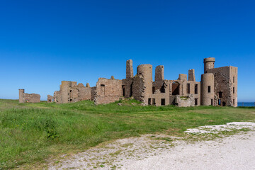 view of the historic Slains Castle ruins under a cloudless blue sky