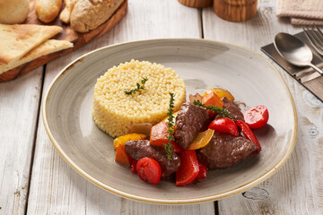 Appetizing beef with gravy and stewed vegetables served with couscous.   