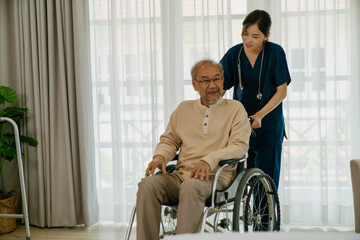 Happy older patient on wheelchair with female nurse