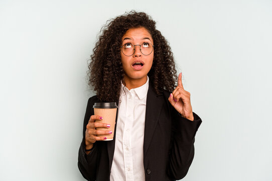 Young business Brazilian woman holding take away coffee isolated on white background pointing upside with opened mouth.