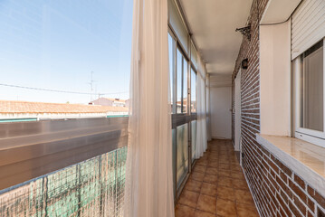 Closed narrow terrace with anodized aluminum glazing and transparent and translucent glass