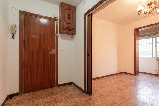 Entrance hall of a residential house with parquet-like sintasol floors, access to an empty room with a large window